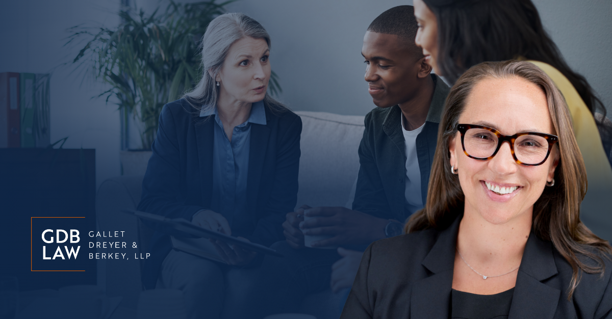 Atty Bruggemann smiling in the foreground, with a blurred background showing a couple sitting down talking to a lawyer.