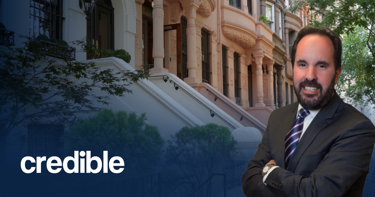 Headshot of Scott Smiler standing with arms crossed in front of brownstone buildings, with the Credible logo displayed in the lower left corner.