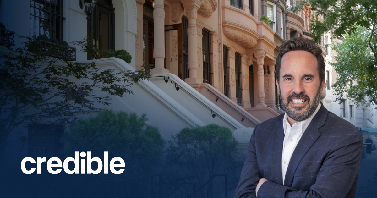 Headshot of Scott Smiler standing with arms crossed in front of brownstone buildings, with the Credible logo displayed in the lower left corner.