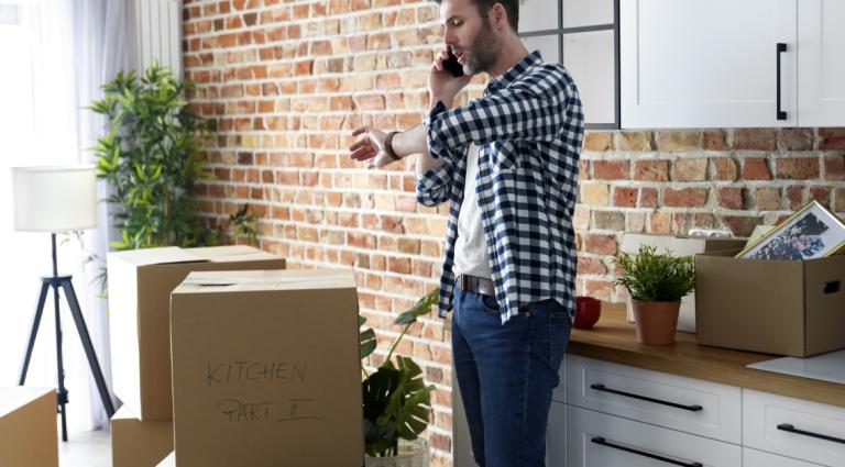 man on the phone surrounded by packed boxes
