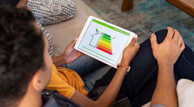 couple looking at tablet with house energy efficiency rating on it