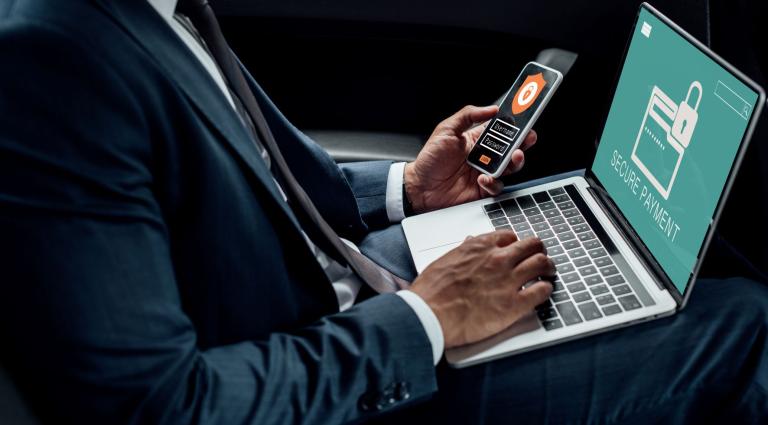 cropped view of businessman using laptop and phone security