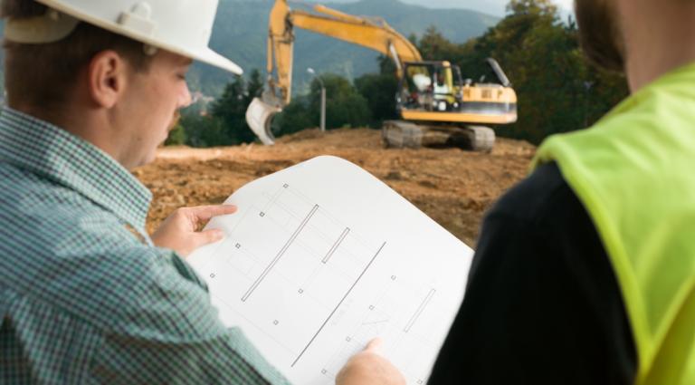 construction workers looking at blueprints
