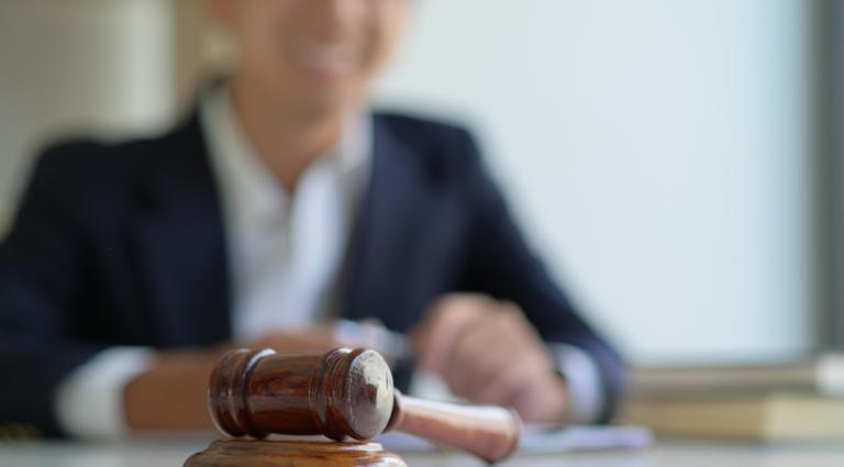 gavel sitting on a table in front of a man