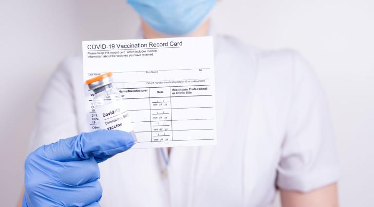 person holding a covid vaccination card