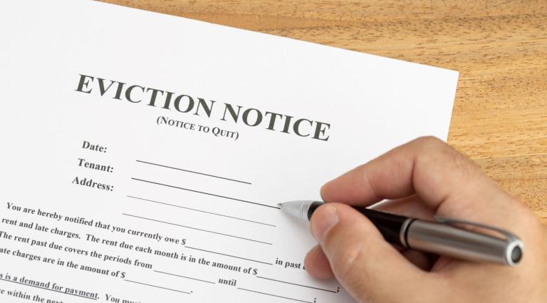 hand ready to fill an eviction notice document