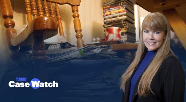 Michelle Quinn in the foreground of an image of a chair messily stacked with papers. 