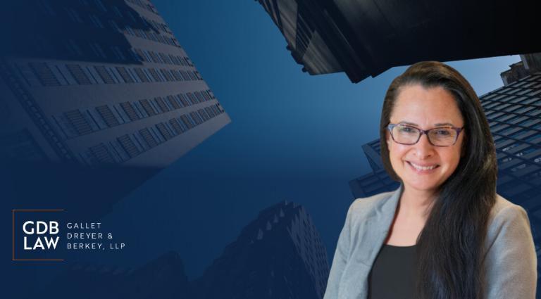Headshot of Beth Gazes, wearing glasses and a gray blazer, smiling against a blue cityscape background with the GDB Law logo.