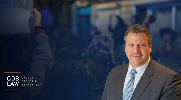Headshot of Joe Farca in a suit over a dark blue background