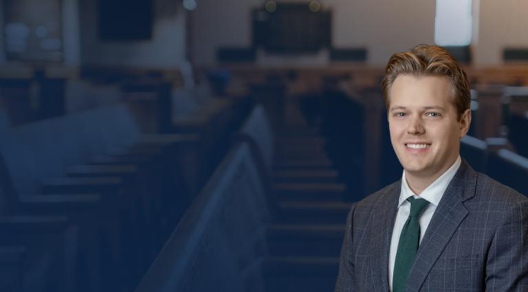 Headshot of Max Ferlesch over a background image of a courtroom